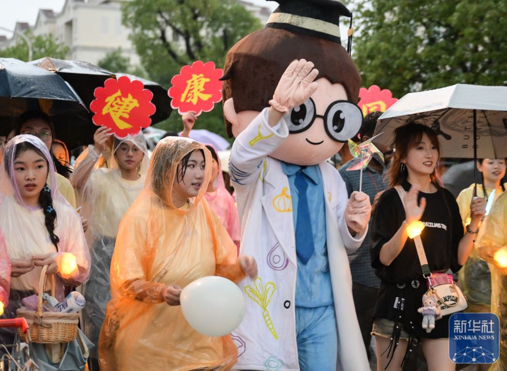 6月21日,yl6809永利官网学生在校园里冒雨巡游。2